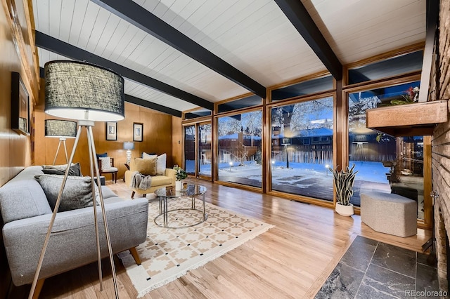 living room with vaulted ceiling with beams, hardwood / wood-style floors, wooden ceiling, and wooden walls