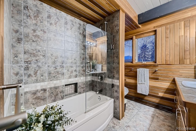 full bathroom with toilet, wood walls, wood ceiling, bath / shower combo with glass door, and vanity