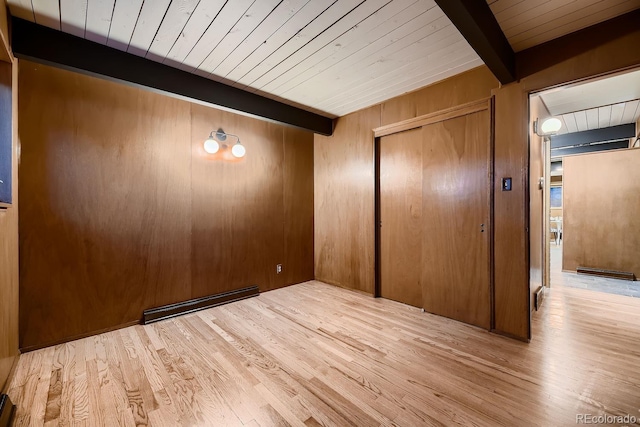 empty room featuring wood ceiling, a baseboard heating unit, beam ceiling, light hardwood / wood-style floors, and wood walls