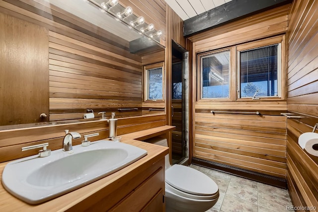 bathroom featuring vanity, toilet, tile patterned flooring, and wood walls