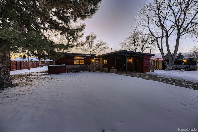 view of snow covered back of property