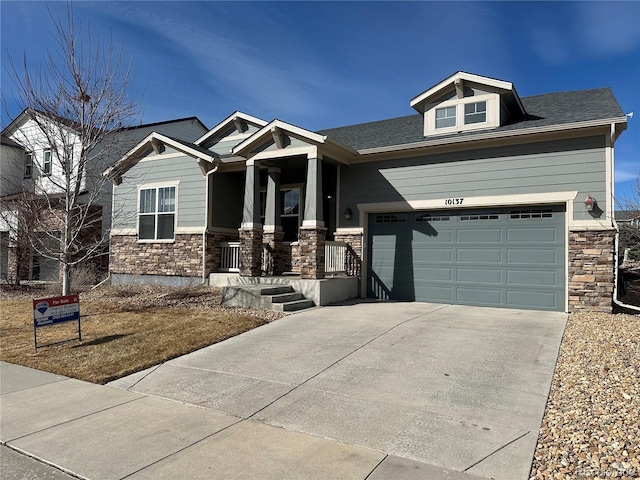 craftsman-style house with stone siding and driveway