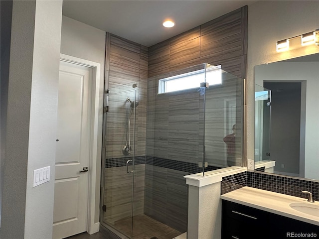 bathroom with vanity, tasteful backsplash, and a stall shower