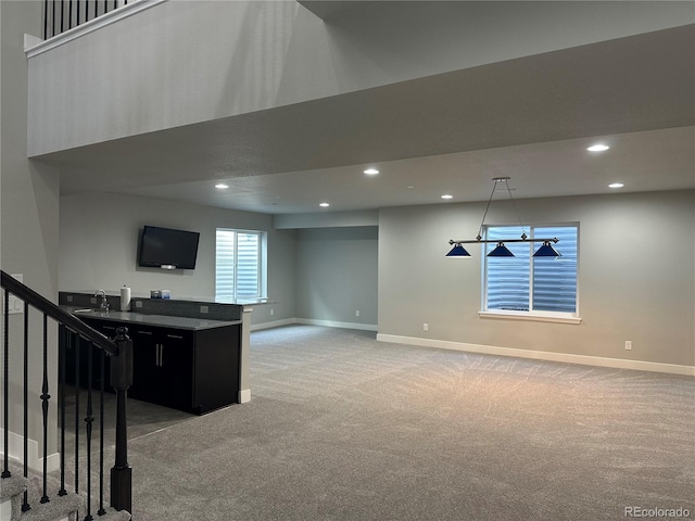 unfurnished living room with stairs, recessed lighting, baseboards, and carpet floors