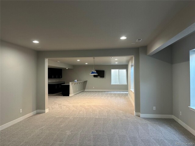 below grade area featuring recessed lighting, baseboards, and light carpet