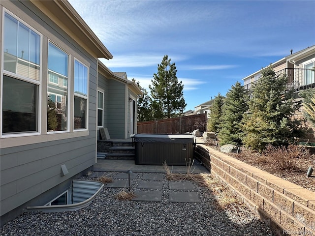 exterior space featuring fence and a hot tub