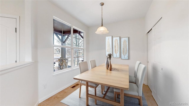 dining space featuring light tile patterned flooring, visible vents, and baseboards