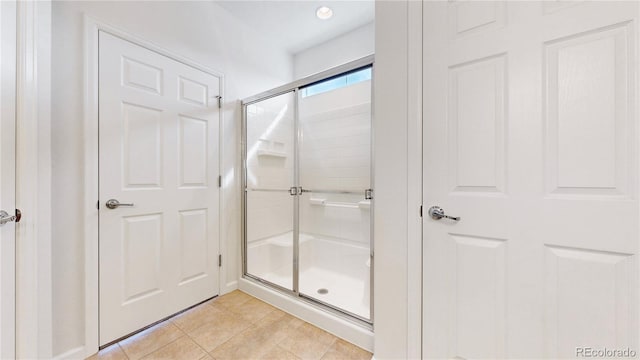 full bathroom featuring a stall shower and tile patterned flooring