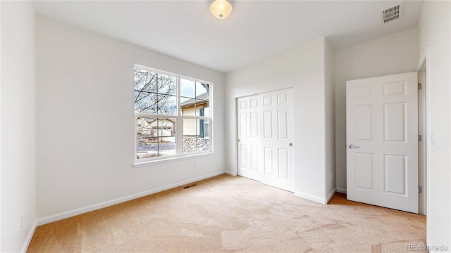 unfurnished bedroom featuring a closet, carpet flooring, visible vents, and baseboards