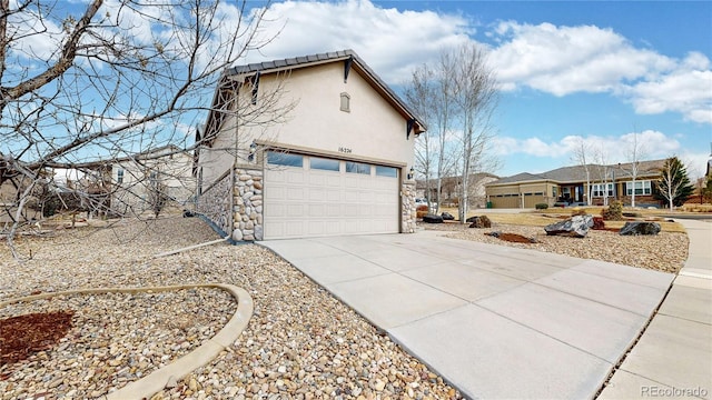 view of property exterior featuring a garage, stone siding, concrete driveway, and stucco siding