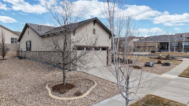 view of property exterior featuring driveway, an attached garage, and stucco siding