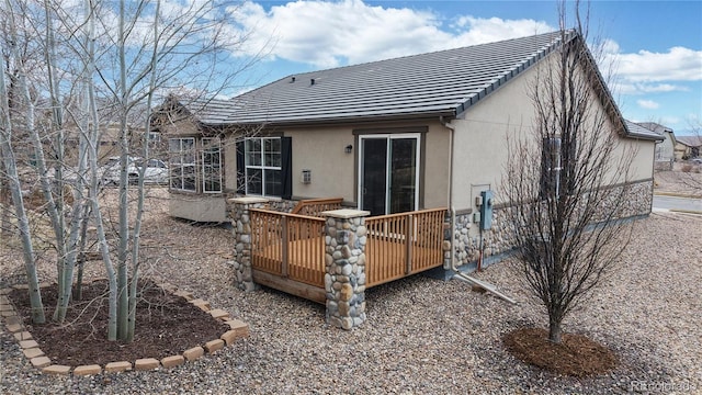 back of property with a wooden deck and stucco siding