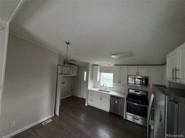 201 Valdai St, Brighton, CO 80603 - kitchen featuring stainless steel appliances, a sink, baseboards, white cabinetry, and dark wood finished floors