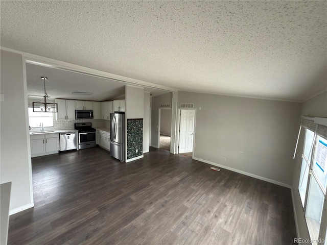 201 Valdai St, Brighton, CO 80603 - unfurnished living room with a textured ceiling, dark wood-style flooring, a chandelier, a sink, and baseboards