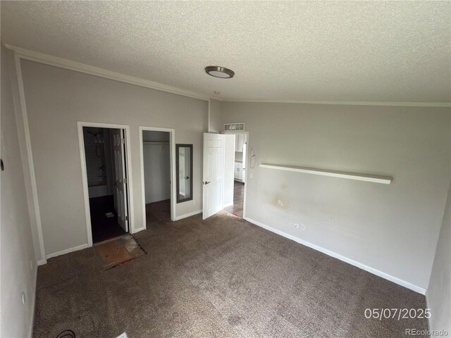 201 Valdai St, Brighton, CO 80603 - unfurnished bedroom with a textured ceiling, carpet floors, ornamental molding, a closet, and a walk in closet