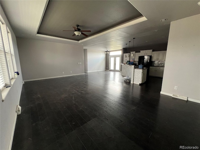 6100 Bluestem Unit 238, Frederick, CO 80530 - unfurnished living room with a raised ceiling, ceiling fan, and dark wood-style floors