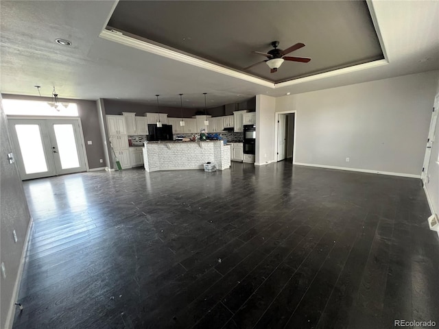 6100 Bluestem Unit 238, Frederick, CO 80530 - unfurnished living room with a raised ceiling, a ceiling fan, dark wood finished floors, french doors, and ornamental molding