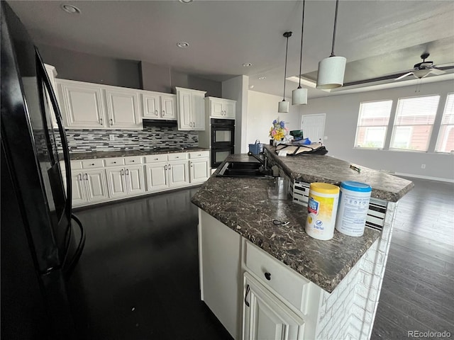 6100 Bluestem Unit 238, Frederick, CO 80530 - kitchen featuring black appliances, a ceiling fan, backsplash, white cabinetry, and a large island