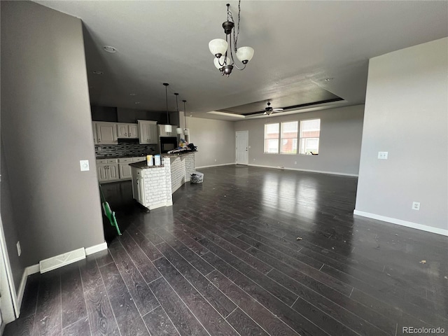 6100 Bluestem Unit 238, Frederick, CO 80530 - unfurnished living room with ceiling fan, dark wood finished floors, a raised ceiling, and a chandelier