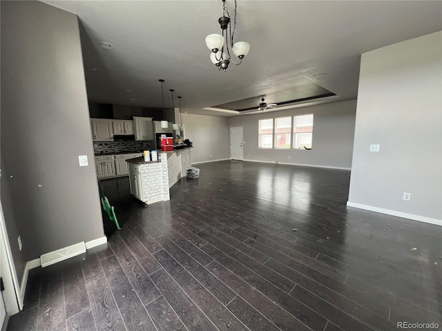 6100 Bluestem Unit 238, Frederick, CO 80530 - unfurnished living room featuring dark wood-style flooring, a ceiling fan, and a raised ceiling