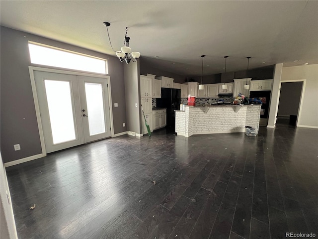 6100 Bluestem Unit 238, Frederick, CO 80530 - unfurnished living room with dark wood-style flooring, french doors, and a chandelier