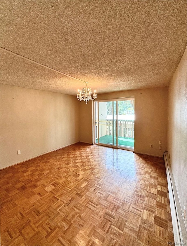 unfurnished room with light parquet flooring, a textured ceiling, baseboard heating, and a chandelier