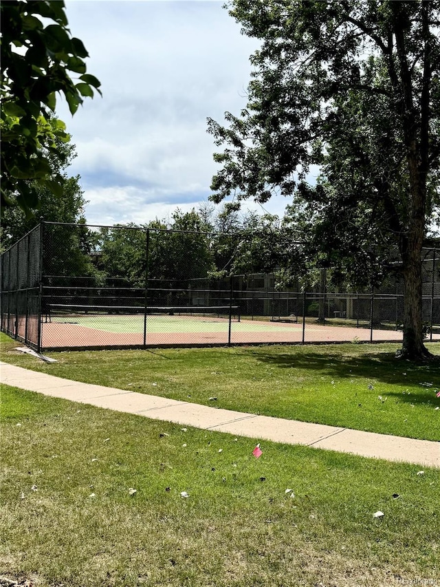 view of tennis court featuring a yard