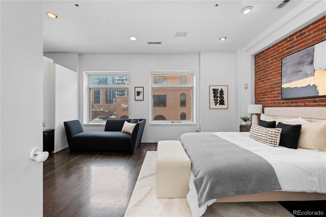 bedroom featuring wood finished floors, brick wall, visible vents, and recessed lighting