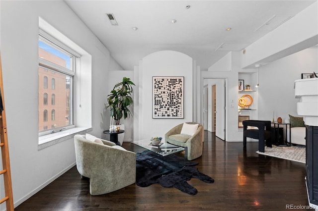 living area featuring visible vents and wood finished floors