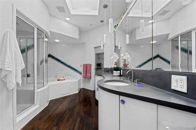 full bathroom with a bath, vanity, visible vents, recessed lighting, and wood finished floors