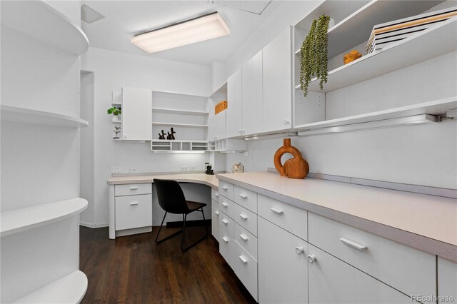office space with dark wood-type flooring and built in study area