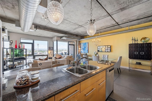 kitchen with sink, a chandelier, stainless steel dishwasher, pendant lighting, and dark stone counters