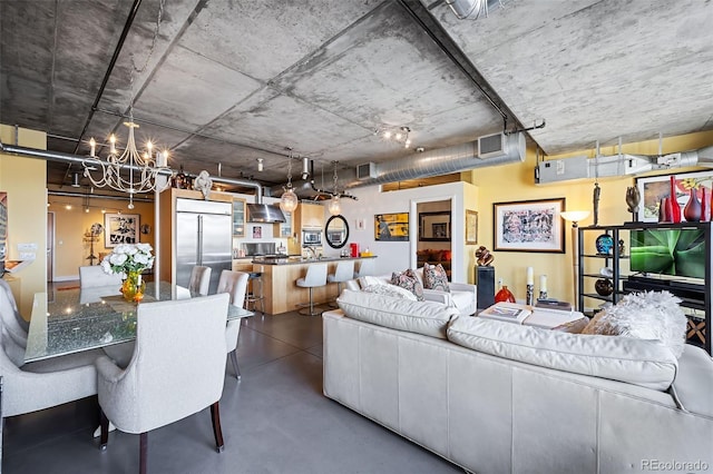 living room with concrete flooring and a chandelier