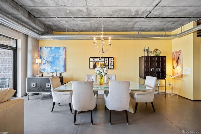 dining area featuring an inviting chandelier and concrete flooring