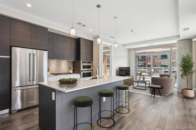 kitchen featuring dark wood finished floors, appliances with stainless steel finishes, modern cabinets, and light countertops