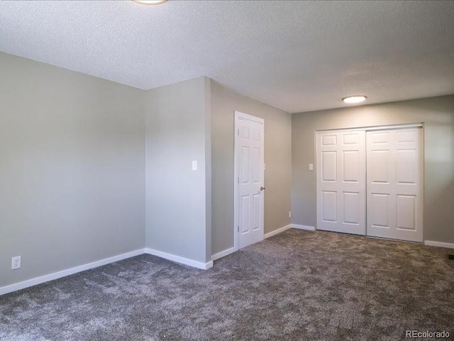 unfurnished bedroom featuring baseboards, a textured ceiling, a closet, and carpet