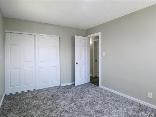 unfurnished bedroom featuring carpet, a closet, and baseboards