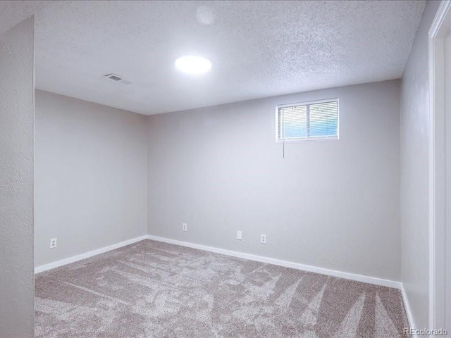interior space featuring a textured ceiling, visible vents, baseboards, and carpet floors