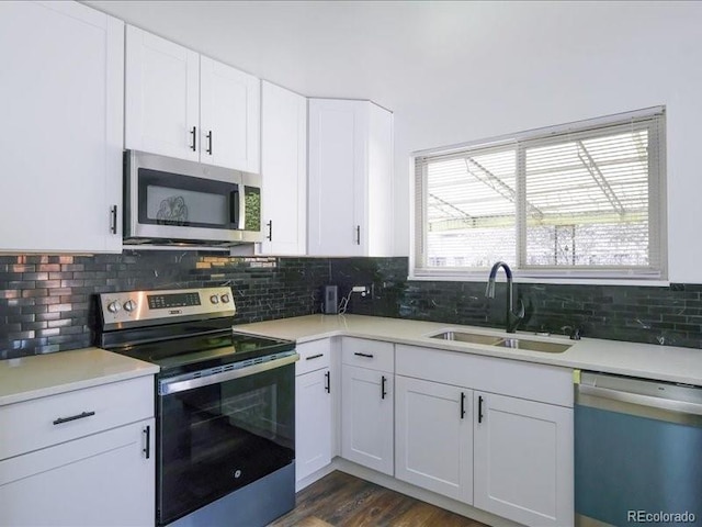 kitchen featuring white cabinetry, decorative backsplash, appliances with stainless steel finishes, and a sink