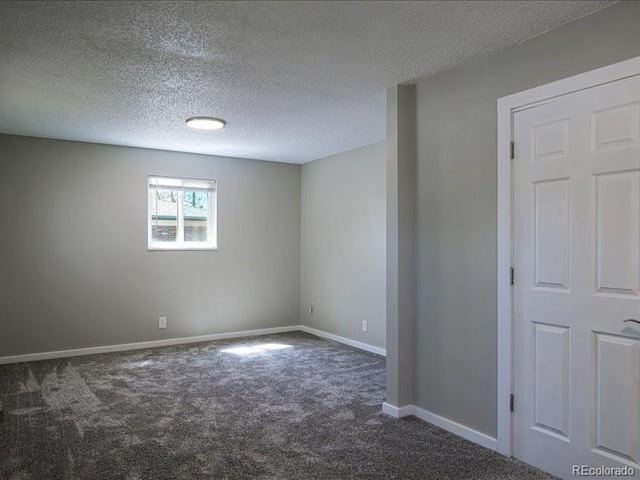 carpeted empty room featuring a textured ceiling and baseboards