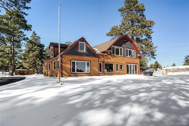 view of snow covered back of property