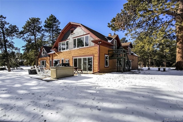 view of snow covered rear of property