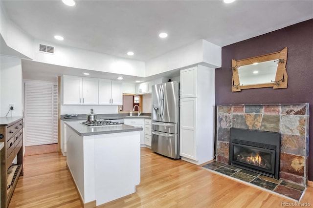 kitchen with white cabinetry, appliances with stainless steel finishes, sink, and light hardwood / wood-style flooring