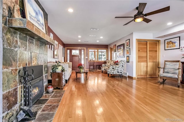 entrance foyer featuring a tiled fireplace, a ceiling fan, recessed lighting, and wood finished floors