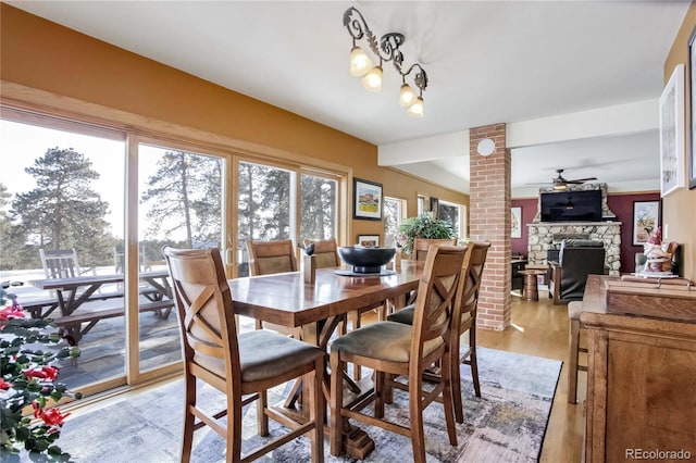 dining room with ceiling fan, light wood-style floors, and a fireplace