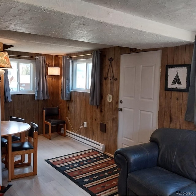 33 S Oak St, Alma, CO 80420 - sitting room featuring a baseboard radiator, wood walls, plenty of natural light, light wood-type flooring, and a textured ceiling
