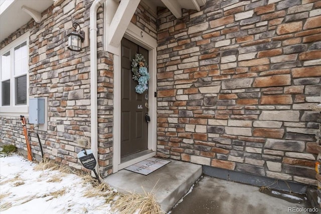 doorway to property with stone siding