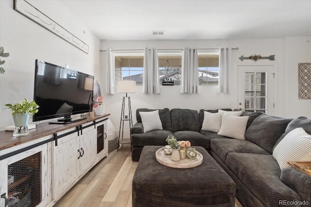 living area with visible vents and light wood-style flooring