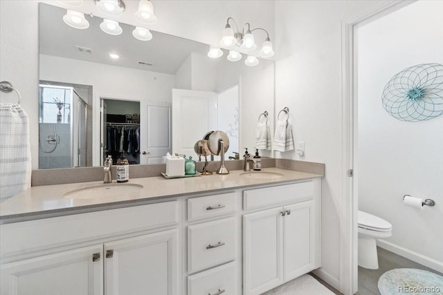 bathroom with double vanity, a stall shower, a sink, and toilet