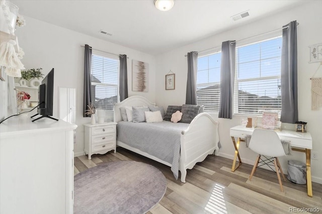 bedroom with visible vents, light wood-style flooring, and multiple windows